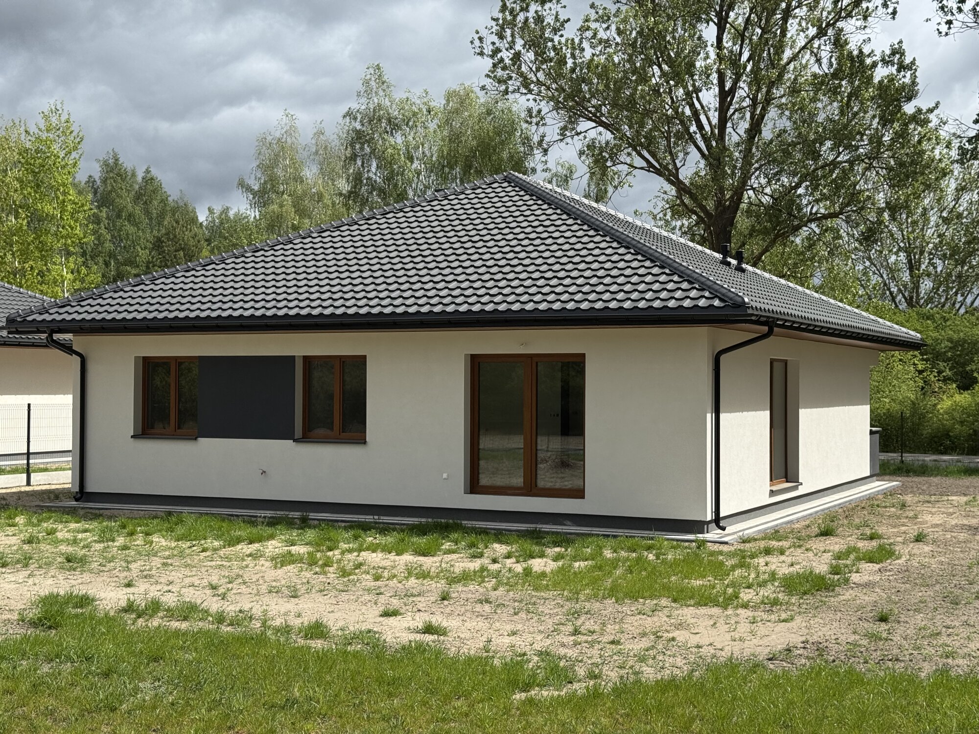 Bryła domu od strony ogrodu na tle zieleni